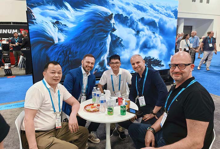 Apexls sales engineers engaging in friendly conversations with clients at the booth